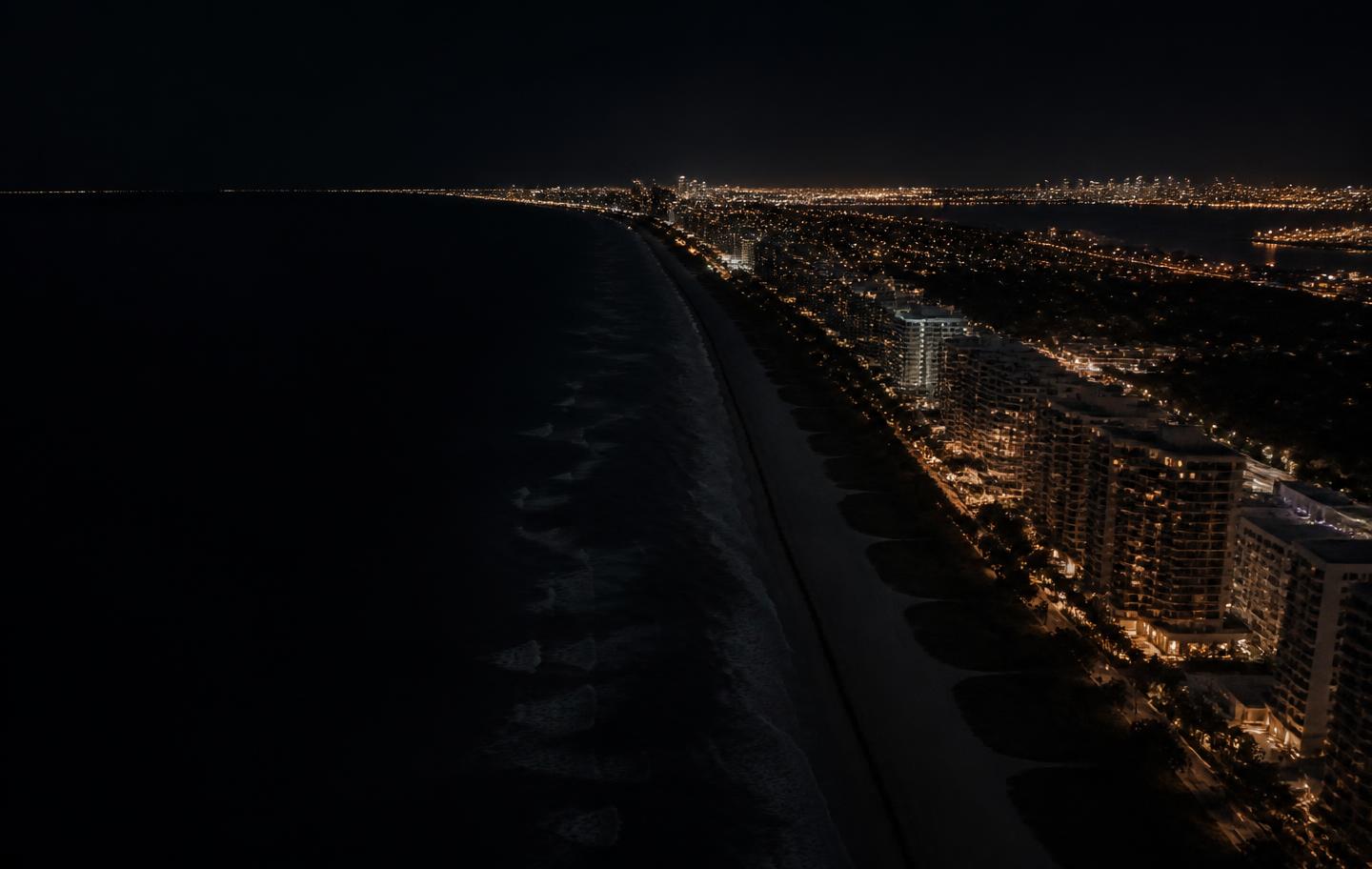 Coastal city lights at night from above